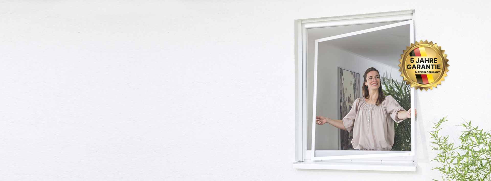 Frau setzt ein Fliegengitter ein mit dem fliegengitter-direkt Qualitätsstempel 5 Jahre Garantie und Made in Germany